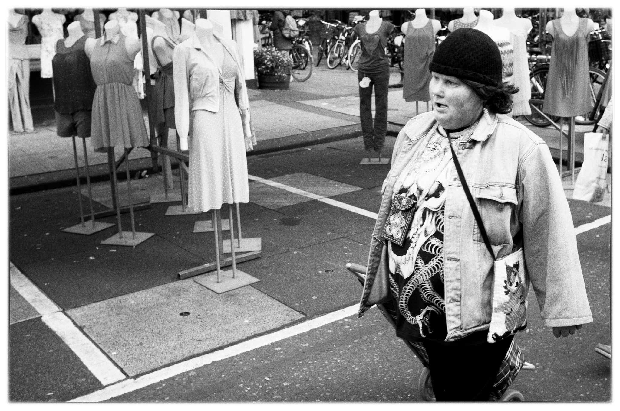 een-vrouw-loopt-langs-zomerjurkjes