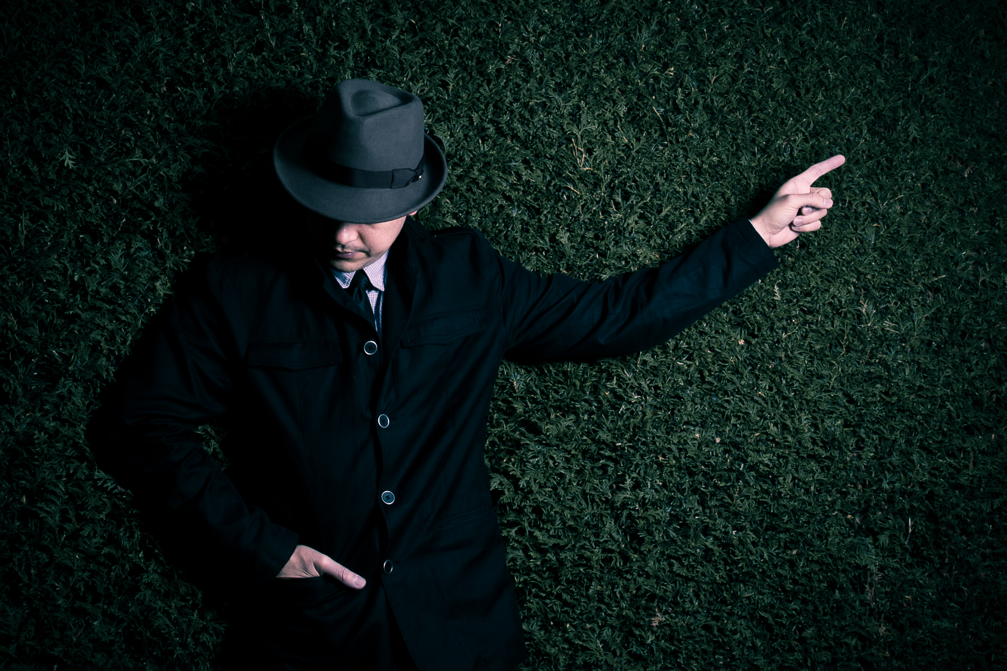 man-met-hoed-bij-heg-1