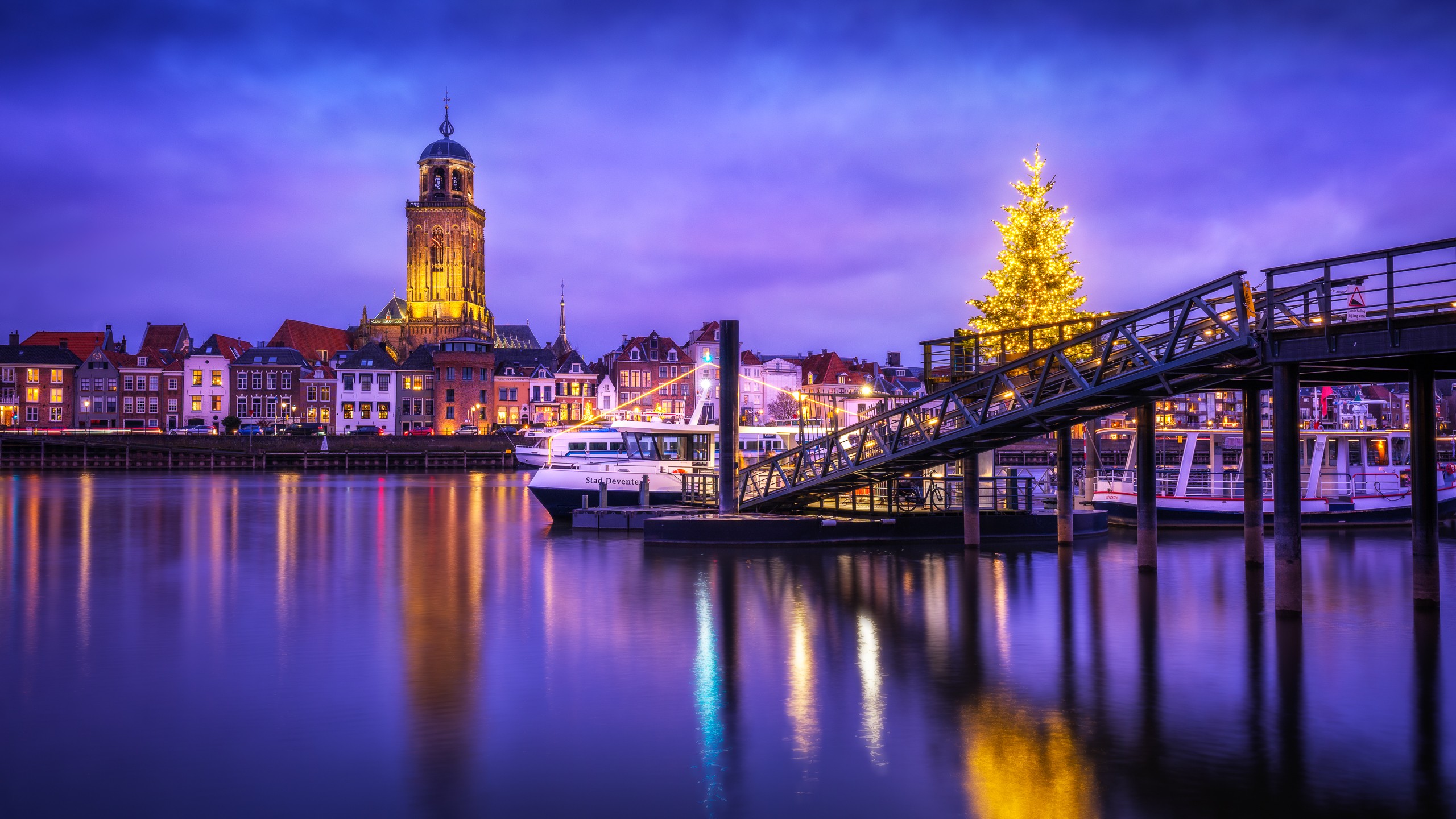 de-kerstboom-tegenover-de-lebuinustoren-in-deventer-tijdens-het-blauwe-uurtje