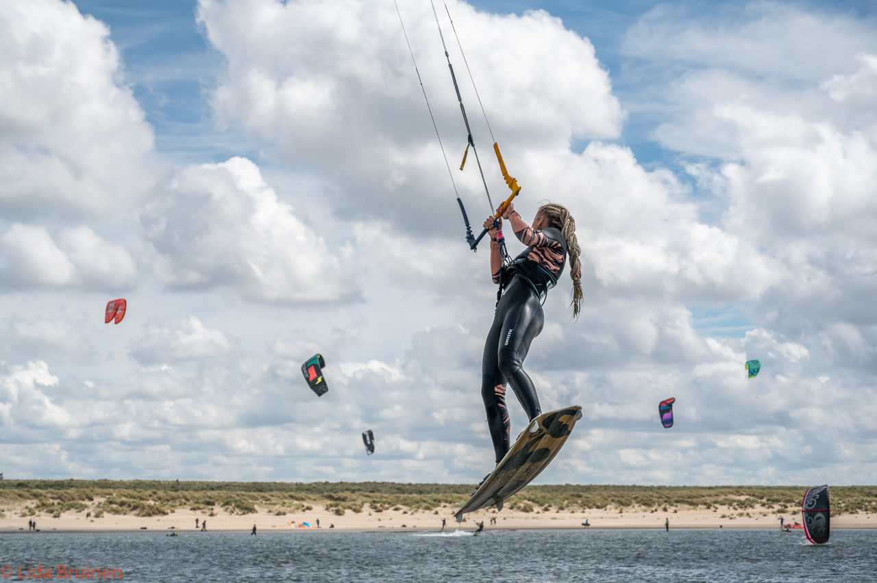 sportvrouw-springt-tijdens-kitesurfen