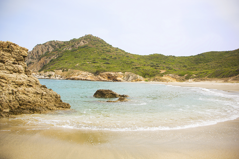 verlaten-strand-tussen-de-groene-bergen