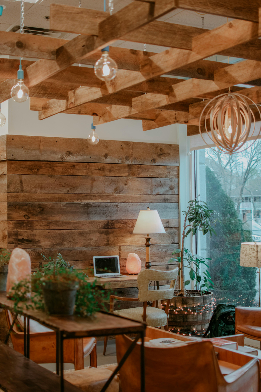 Image: Interior of a light modern conservatory with a lot of glass, wooden finish, and a laptop on a table for hybrid working